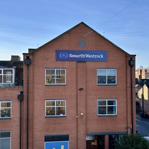 Brick office building facade with a blue SmurfitWestrock sign above the entrance