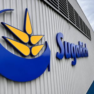Exterior of a building with a large blue and yellow logo and the word 'SugRich' on corrugated metal siding.