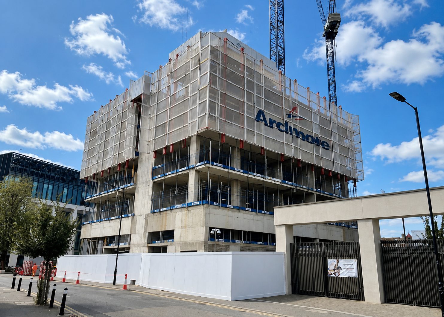A partially constructed building with a visible concrete frame and protective