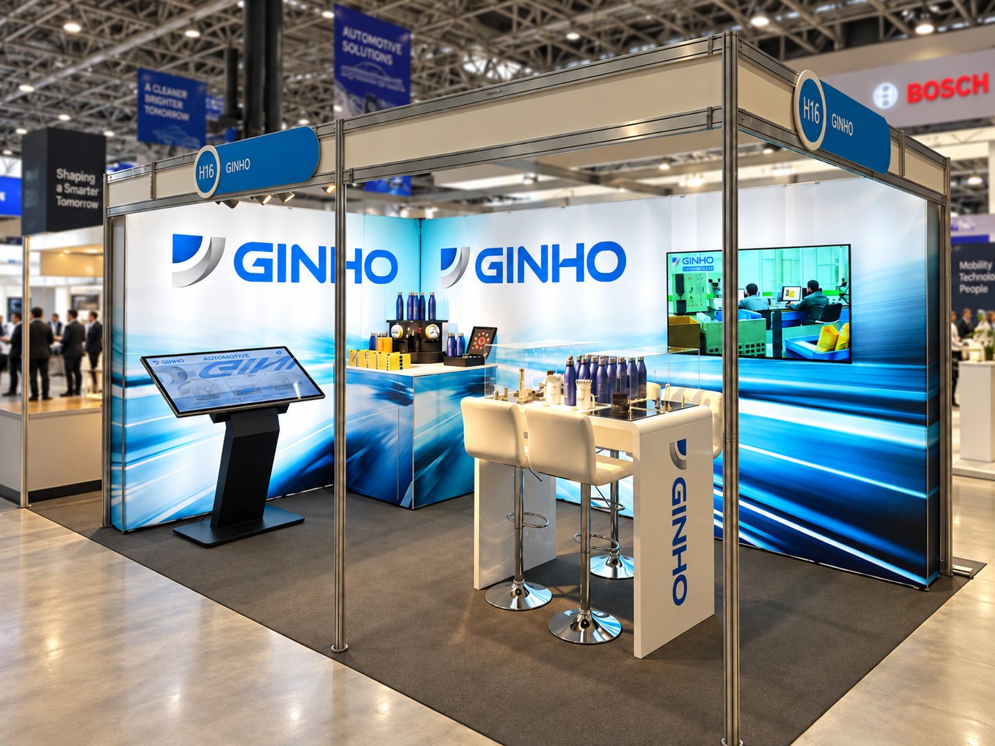 GINHO trade show booth with blue branding, large backlit panels reading GINHO, touchscreen kiosk, and white bar-height seating area at the booth.