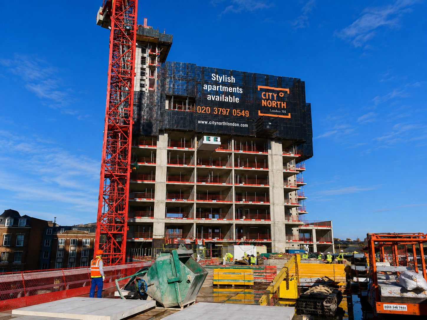 Under-construction high-rise with a red crane and a billboard advertising stylish apartments by City North London on a bright day.