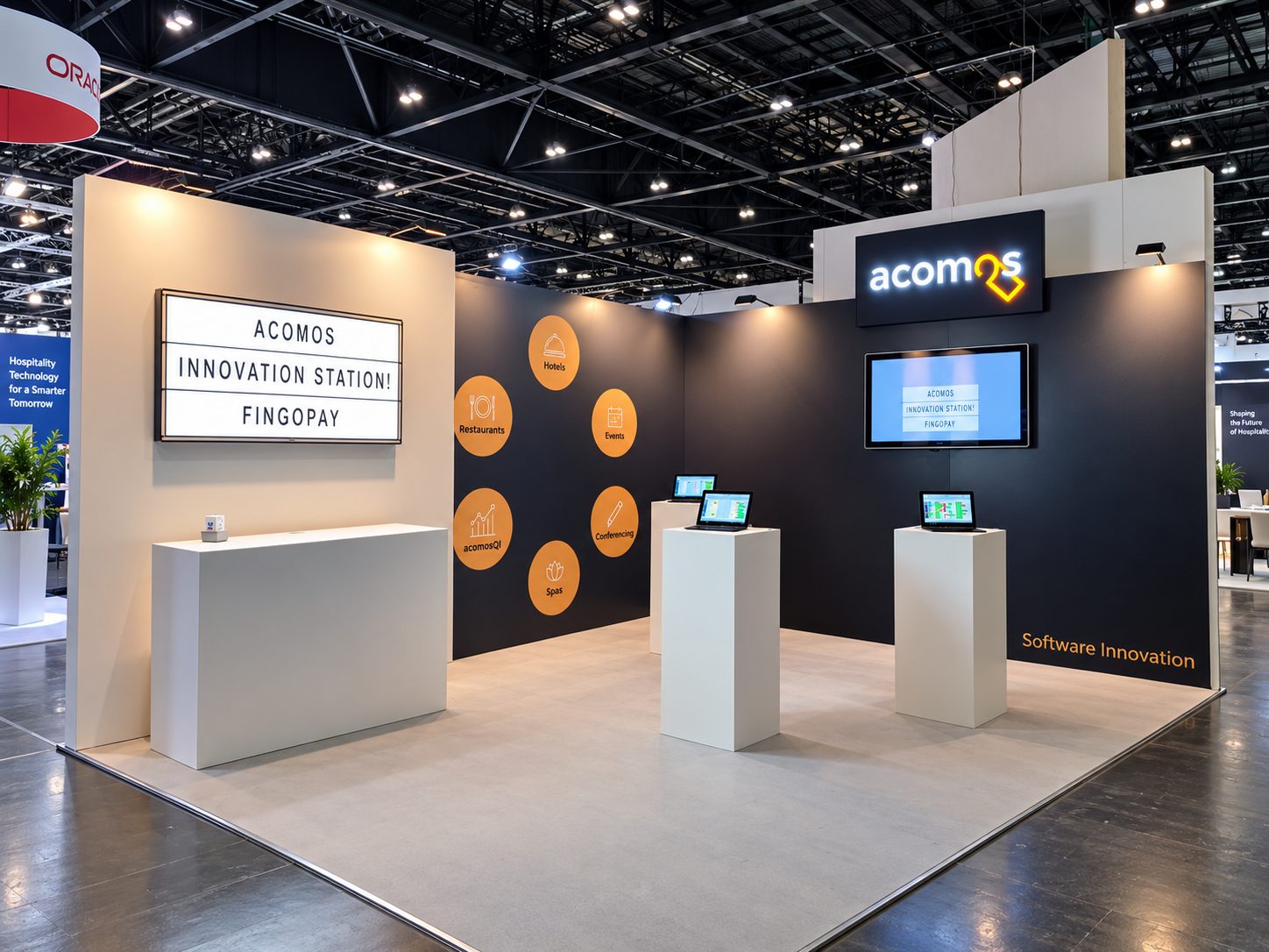 Exhibition booth for ACOMOS with an illuminated sign, orange circular icons on a dark wall, and laptops on white pedestals.