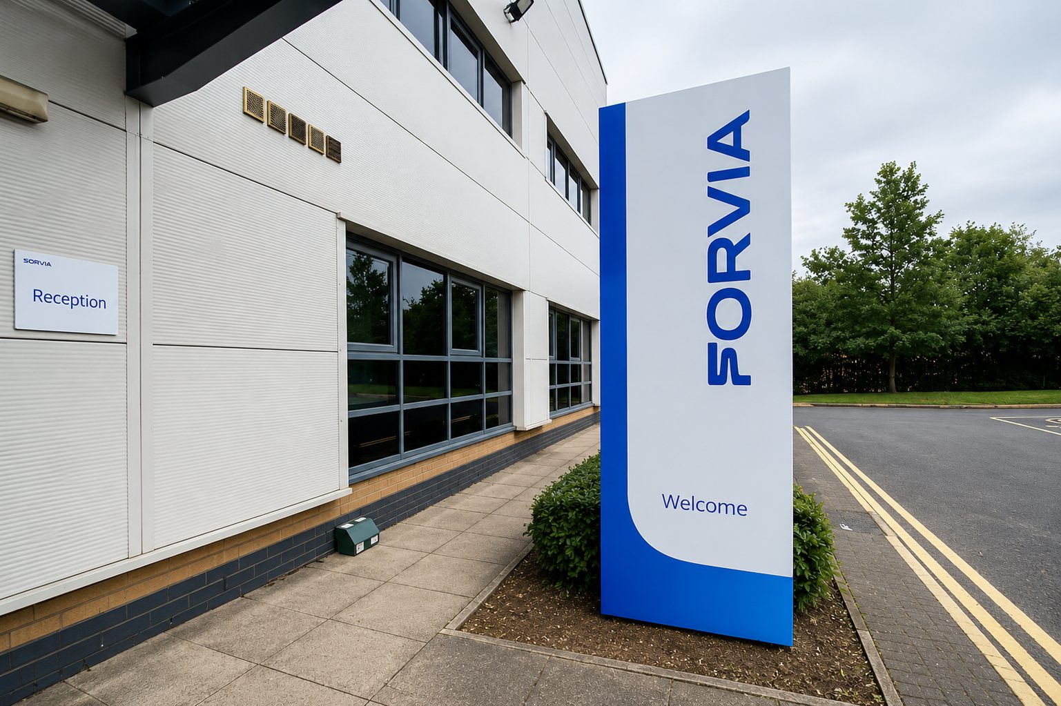 Exterior of a modern office building with a large vertical sign reading SORVIA and a wall-mounted Reception sign.