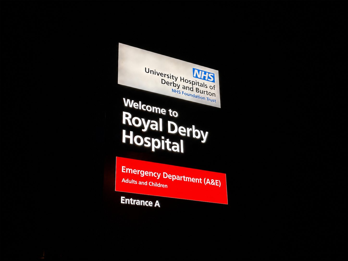 Signage for Royal Derby Hospital, featuring NHS branding. It directs to the