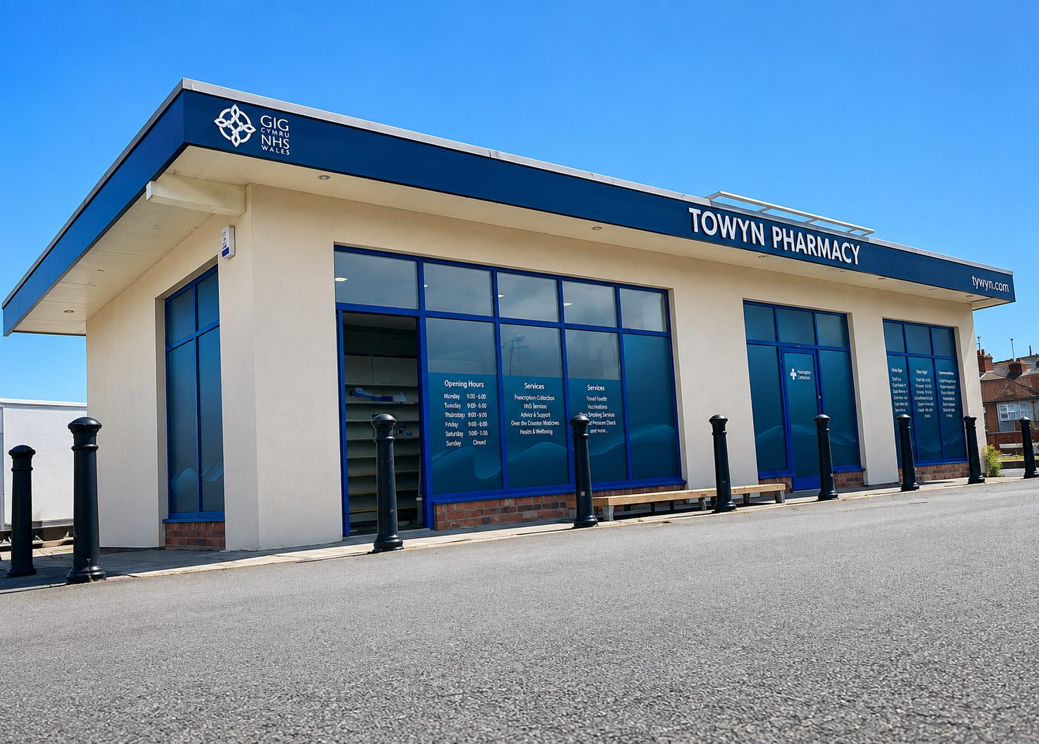 Towyn Pharmacy storefront with blue-framed windows on a sunny day.