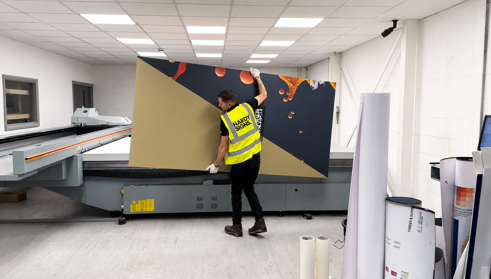 Colorful construction hoarding displays vibrant artwork and project information