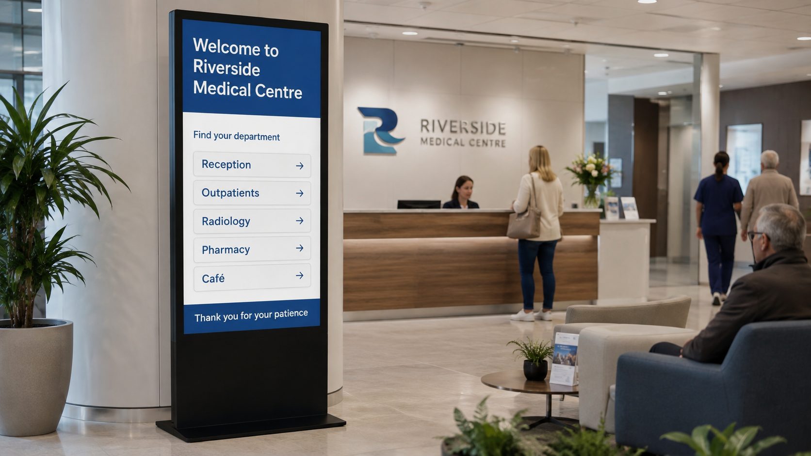 Lobby at Riverside Medical Centre with a tall digital directory listing departments (Reception, Outpatients, Radiology, Pharmacy, Café) and a reception desk; people seated and standing nearby.