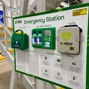 Emergency Station board with First Aid Kit, Eye Wash Station, and Defib in an industrial setting