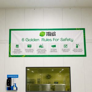 Banner reading 'Hello Fresh: 6 Golden Rules For Safety' with six green icons outlining safety rules in a clean industrial room.