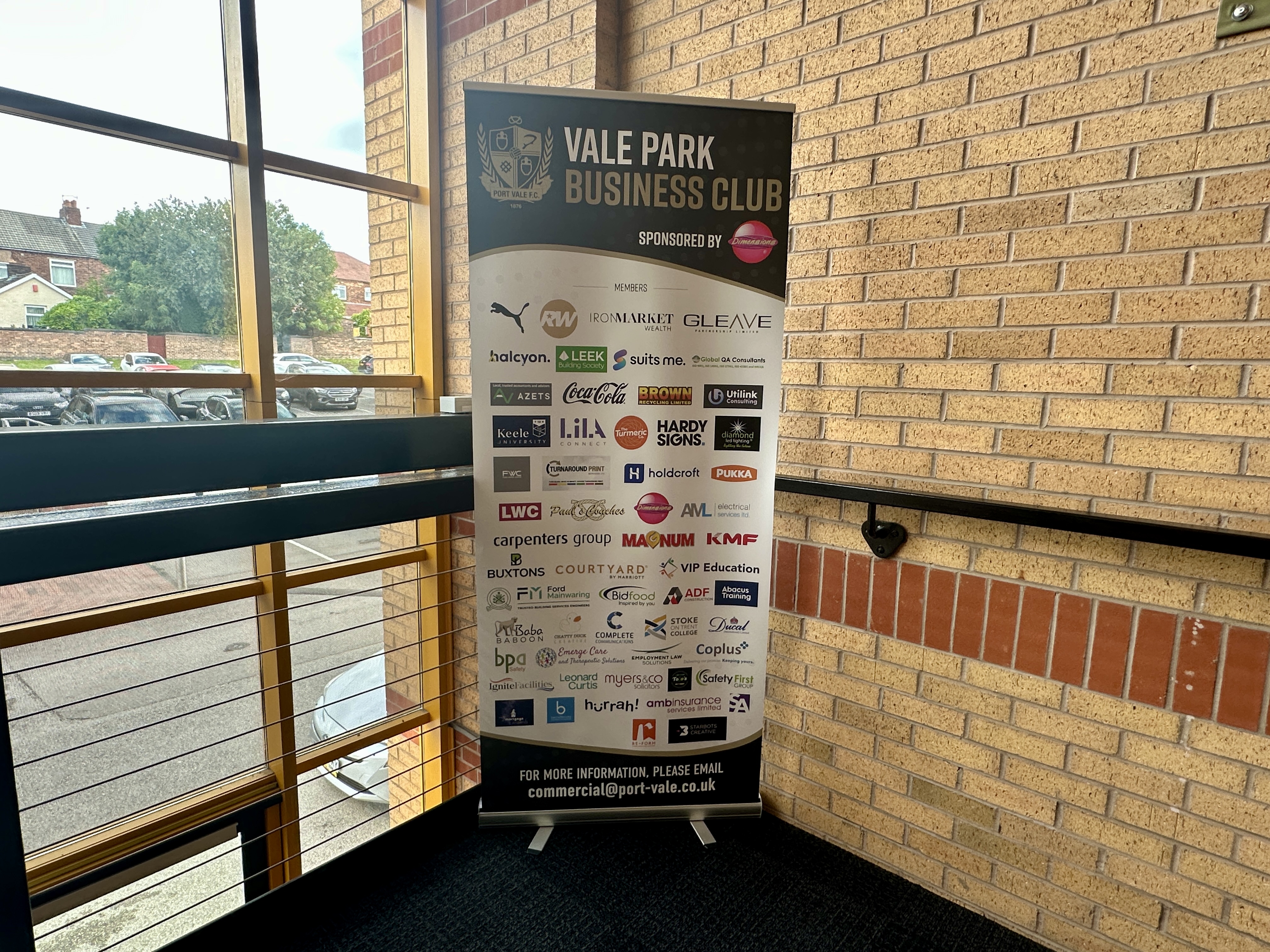 Tall sponsor banner for Vale Park Business Club in a brick-walled interior, displaying numerous sponsor logos.